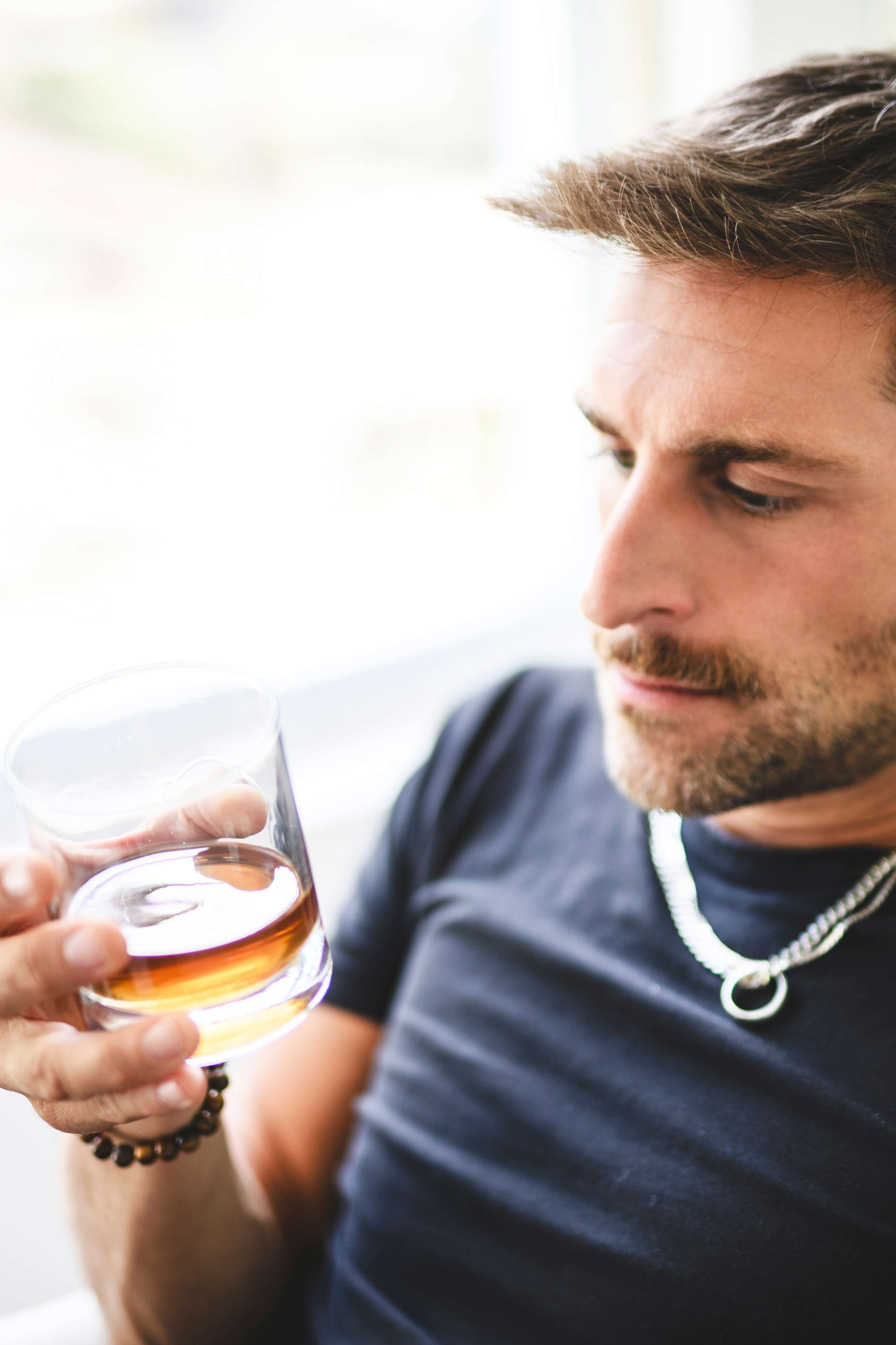addiction-recovery-treatment-08 Man with glass of Whiskey wondering if he is an alcoholic.